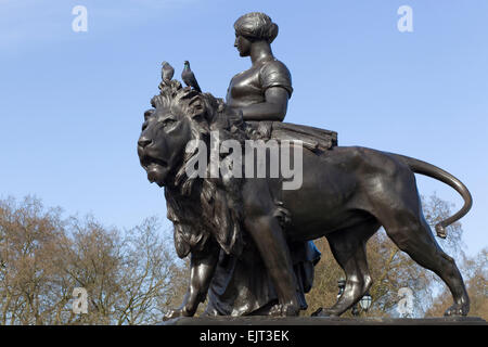 Femme en bronze doré et le Monument du Lion de Victoria à Londres en Angleterre Banque D'Images