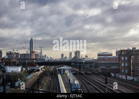 Lignes de train menant vers la ville de Londres sous un ciel lourd Banque D'Images