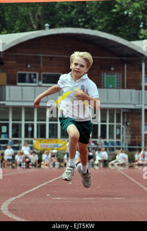 Un garçon sprints pour la ligne en une journée du sport scolaire Banque D'Images