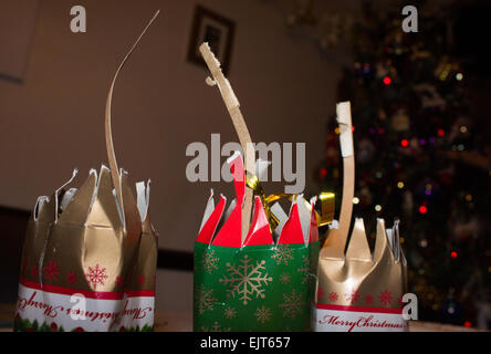 Tiré des craquelins montrant l'employé s'enclenche après un dîner de Noël sur une table devant un arbre de Noël avec des lumières sur. Banque D'Images