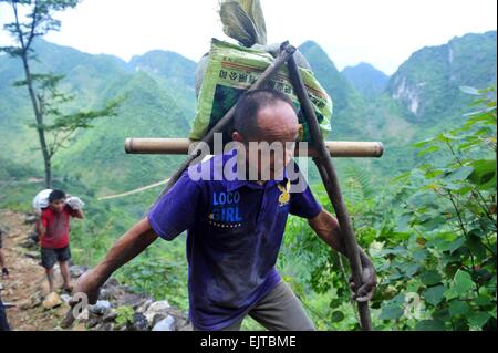 (150401) -- "LIUTONG, 1er avril 2015 (Xinhua) -- ?Un villageois porte sur son dos les ciments dans Nongwei Bansheng de village, canton sud-ouest de la Chine, région autonome Zhuang du Guangxi, le 18 juin 2014. En raison de l'absence de plaine, la plupart des familles dans les zones montagneuses de l'ouest "Liutong construire leurs maisons sur les collines. Dans Qibainong Bansheng et comtés de "Liutong, gens de l'ethnie Miao ont vécu dans les montagnes pendant environ mille ans. Ils comptent sur la plantation des cors pour leur subsistance. Trois étages bâtiment guindée est l'architecture traditionnelle du style dans les deux comtés. Les gens r Banque D'Images