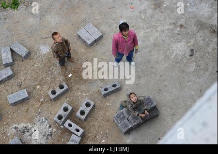 (150401) -- "LIUTONG, 1er avril 2015 (Xinhua) -- ?le 38-year-old fil Xiuying (R, supérieur) attend pour soulever les briques dans Nongding Bansheng de village, canton sud-ouest de la Chine, région autonome Zhuang du Guangxi, le 28 février 2015. En raison de l'absence de plaine, la plupart des familles dans les zones montagneuses de l'ouest "Liutong construire leurs maisons sur les collines. Dans Qibainong Bansheng et comtés de "Liutong, gens de l'ethnie Miao ont vécu dans les montagnes pendant environ mille ans. Ils comptent sur la plantation des cors pour leur subsistance. Trois étages bâtiment guindée est l'architecture traditionnelle dans le style Banque D'Images