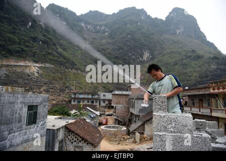 (150401) -- "LIUTONG, 1er avril 2015 (Xinhua) -- ?le 40-year-old Meng Guirong construit sa nouvelle maison dans Village de Nongding Bansheng Township, dans le sud-ouest de la région autonome Zhuang du Guangxi, le 28 février 2015. En raison de l'absence de plaine, la plupart des familles dans les zones montagneuses de l'ouest "Liutong construire leurs maisons sur les collines. Dans Qibainong Bansheng et comtés de "Liutong, gens de l'ethnie Miao ont vécu dans les montagnes pendant environ mille ans. Ils comptent sur la plantation des cors pour leur subsistance. Trois étages bâtiment guindée est l'architecture traditionnelle du style dans les deux counti Banque D'Images