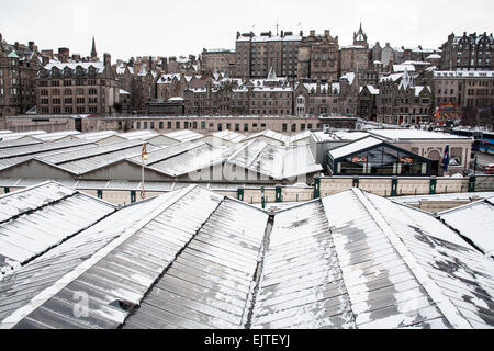 Vue sur la vieille ville d'édimbourg avec le toit couvert de neige de la gare de Waverley, au premier plan. Banque D'Images