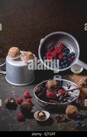 Plaque en aluminium avec le mélange de chocolat pour faire des truffes au chocolat et les truffes au chocolat maison avec les baies fraîches sur dar Banque D'Images