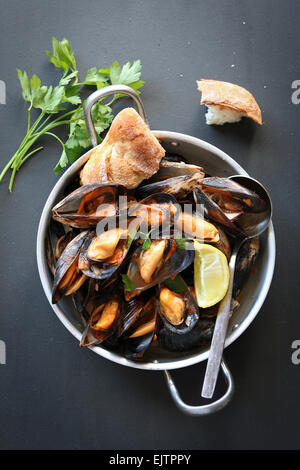 Les moules cuites à la sauce tomate garnie de persil Banque D'Images