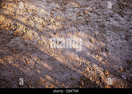 Potager fraîchement creusée dans un couvert de gel au début du printemps dans l'ombre et de la lumière du soleil. UK Banque D'Images