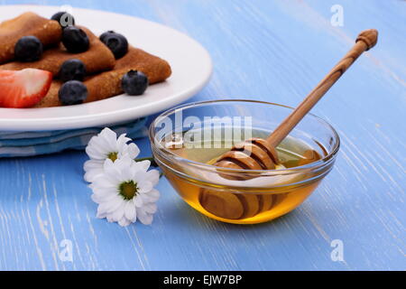 Crêpes au miel et balancier en bois bleu sur, Close up Banque D'Images