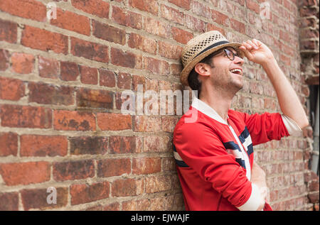 Portrait of mid adult man in front of brick wall Banque D'Images