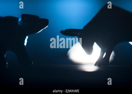 Silhouettes de figurines de Bull and Bear dans spot light Banque D'Images