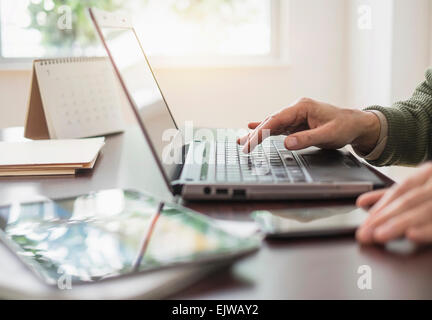 Close up of man's hands using laptop at desk Banque D'Images