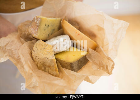 Close up of man's hand holding les tranches de fromage dans du papier Banque D'Images