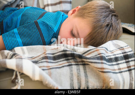 Boy (6-7) sleeping on sofa Banque D'Images