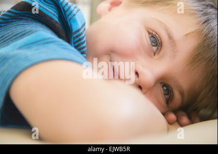 Boy (6-7) relaxing on sofa Banque D'Images