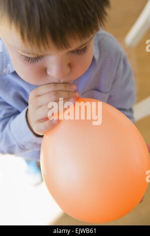 Boy (6-7) ballon gonflage Banque D'Images