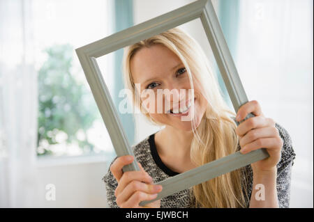 Woman holding photo frame Banque D'Images