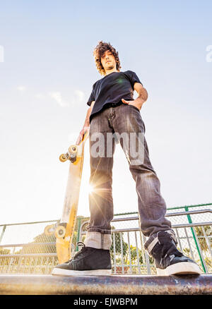 USA, Floride, West Palm Beach, Man leaning on skateboard en skatepark Banque D'Images
