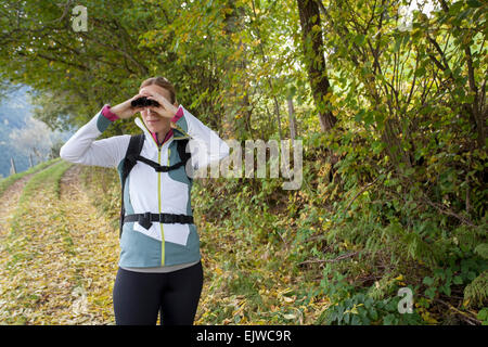 L'Autriche, Salzburger Land, Maria Alm, Woman looking through binoculars Banque D'Images