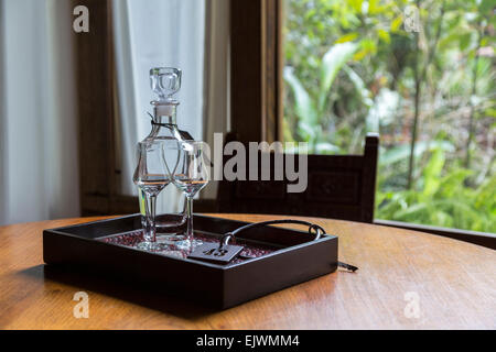 Le Pérou, Machu Picchu Pueblo. Pisco Brandy dans Decanter avec lunettes et clé de la Chambre. Banque D'Images