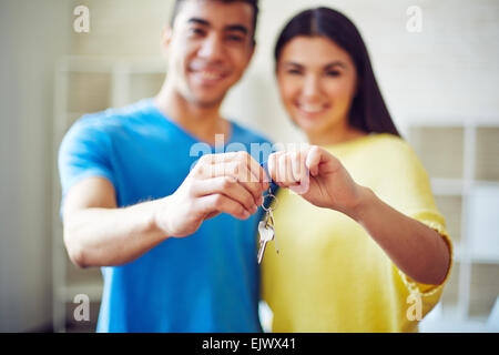 Jeune couple montrant la clé de leur nouvelle résidence Banque D'Images