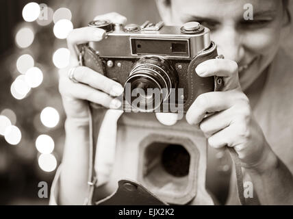 Smiling woman photographié retro camera. Noir - Blanc traitement de l'image. Banque D'Images