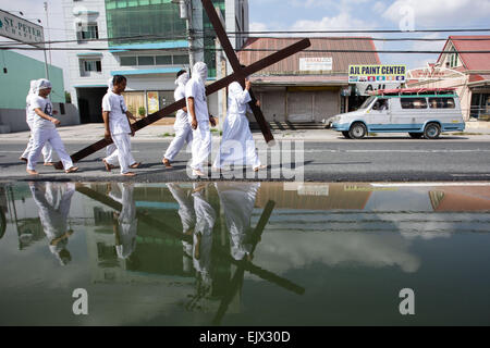 Pampanga, Philippines. Apr 02, 2015. Les Pénitents se reflètent dans une flaque d'eau le Jeudi Saint, le 2 avril 2015. Chaque année pendant la Semaine Sainte, des centaines de pénitents accomplir des actes de pénitence comme l'auto-flagellation, marche pieds nus, portant une croix et l'auto-crucifixion partout aux Philippines, à majorité d'un pays catholique. Credit : Mark Cristino/Pacific Press/Alamy Live News Banque D'Images