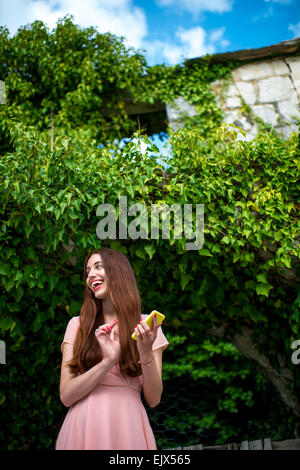 Femme à l'aide de téléphone sur fond de lierre vert Banque D'Images