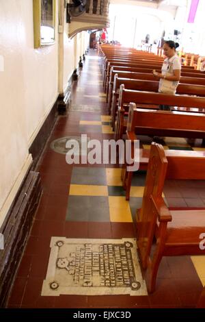 Manille, Philippines. 30Th Mar, 2015. Un dévot de prendre la prière en face de la gare de la croix à l'intérieur de San Ildefonso De Toledo Église paroissiale de Tanay, Rizal avec une pierre tombale sur le sol qui sont communs sur les vieilles églises. L'église de San Ildefonso De Toledo Église paroissiale de Tanay, Rizal (province de l'Est de Manille) fait un monument historique et première des Philippines qui en font un arbre millénaire de l'Acacia pour devenir une icône ou d'un Saint. © Gregorio B. Dantes Jr./Pacific Press/Alamy Live News Banque D'Images