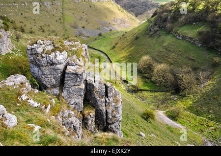 Parsons Tor dans Lathkill Dale sur une journée de printemps ensoleillée. Regardez vers le bas dans la dale avec rochers calcaires au premier plan. Banque D'Images