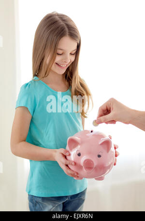 Smiling little girl holding piggy bank Banque D'Images