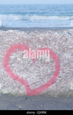 Coeur rouge peint à la bombe sur le mur en arrière-plan de la mer Banque D'Images