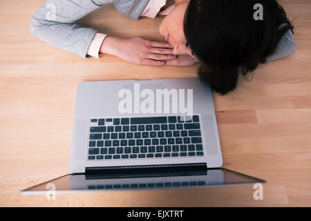 Jeune femme dormir sur la table en bois avec coffre Banque D'Images