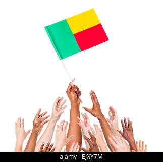 Groupe de personnes pour atteindre et tenant le drapeau du Bénin Banque D'Images