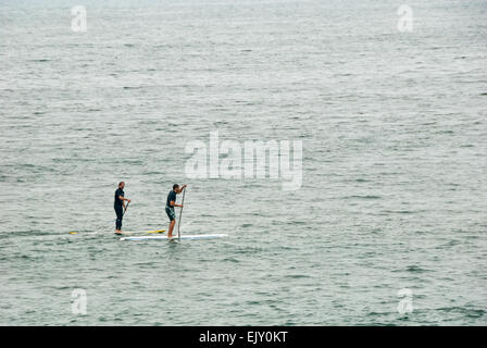 Stand-up Paddling paddleboarders le long de la côte à Manhattan Beach, Californie, USA. Banque D'Images