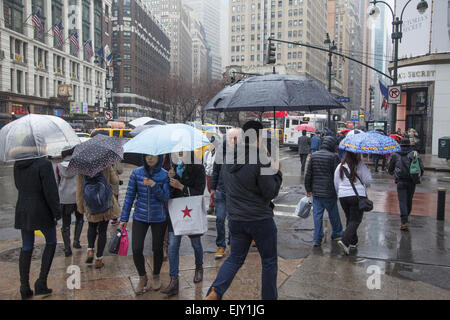 La rue reste occupé avec parasols jusqu'à ce jour pluvieux de Midtown Manhattan. Banque D'Images