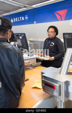 Romulus, Michigan - Un Delta Air Lines ticket agent vérifie dans un passager à l'aéroport Detroit Metro Banque D'Images