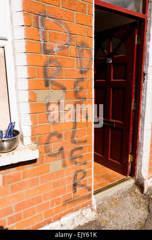 'Drug Dealer" écrit sur le mur à l'extérieur d'une maison par des paramilitaires loyalistes les menaçant de sortir de la zone d'être 'dealt avec'. Belfast, Irlande du Nord. Banque D'Images