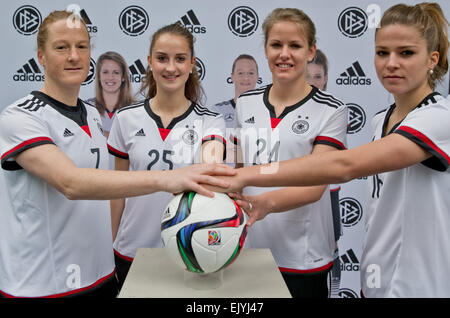 Les joueurs de l'équipe nationale de soccer womens allemande Lena Petermann (L-R), Sara Daebritz, Melanie Behringer et Melanie Leupolz posent dans leurs nouveaux maillots et le ballon officiel pour la FIFA 2015 Coupe du Monde féminine à Herzogenaurach, Allemagne, 02 avril 2015. Photo : Daniel Karmann/dpa Banque D'Images