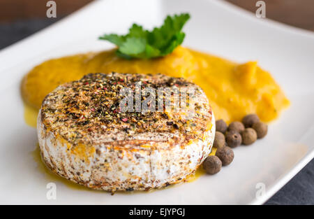 Camembert grillé aux épices et purée de potiron on White Plate Banque D'Images