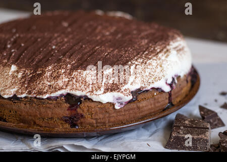 Gâteau au chocolat avec crème fouettée saupoudrée de cacao en Close Up Banque D'Images