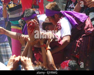 Bulacan, Philippines. 06Th avr, 2015. Dix hommes et une femme a été clouée sur la croix boisée au cours de la crucifixion réelle rituel le Vendredi saint en Kapitangan village, municipalité de Paombong dans la province de Bulacan, nord des Philippines. Des centaines de touristes locaux et étrangers a été témoin de cette activité frénétique. Sherbien Dacalanio : Crédit/Pacific Press/Alamy Live News Banque D'Images