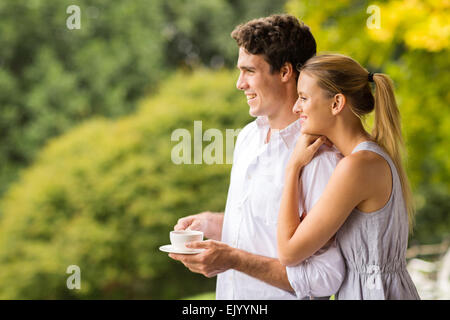 Young couple avec tasse de café à la suite Banque D'Images