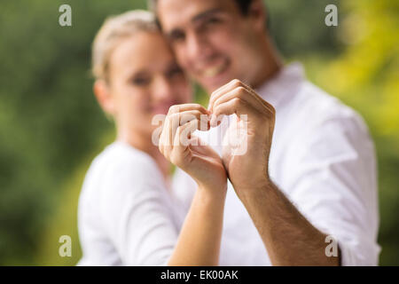 Charmante jeune couple coeur avec les mains Banque D'Images