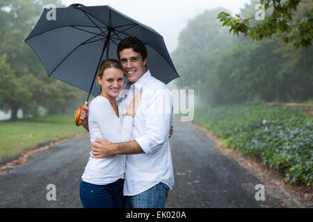 Cute young couple sous un parapluie dans la brume Banque D'Images