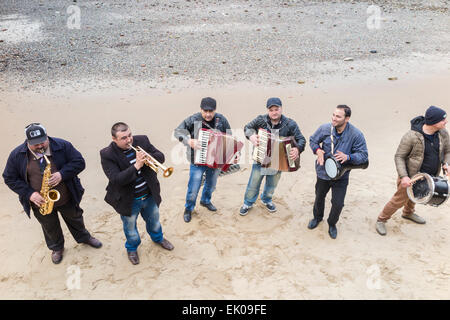 Une bande d'amuseurs de l'exécution musicale pour des conseils sur une plage de sable à marée basse sur la rive sud de la rivière Thames Embankment, London Borough of Southwark, SE1 Banque D'Images