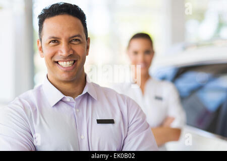 Car salesman standing in front of collègue in showroom Banque D'Images