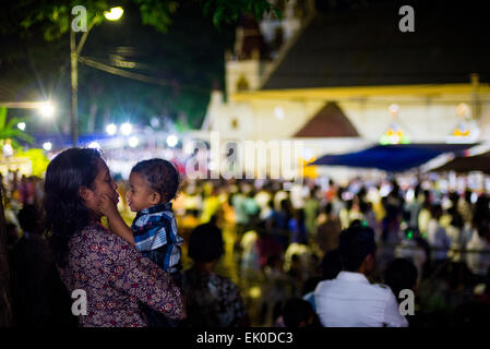 Larantuka, Indonésie. 3rd avril 2015. Une mère calme son enfant lors de la cérémonie de masse du jeudi Saint à l'église de la cathédrale de Larantuka, sur l'île de Flores, en Indonésie. Banque D'Images