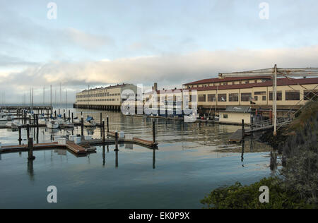 Soir sur les eaux miroitantes Gashouse Marina à Fort Mason un bâtiment, Pier 1 et l'advection Brouillard sur San Francisco Bay Banque D'Images