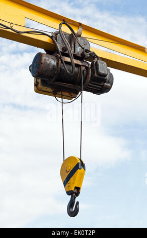 Moteur de grue avec crochet et sur les câbles en acier sur fond de ciel nuageux Banque D'Images