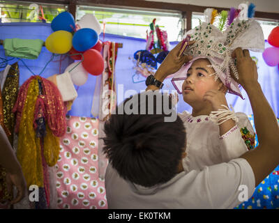 Chiang Mai, Thaïlande. 4ème apr 2015. Les hommes aident un garçon entrer dans son costume de cérémonie pour le Poi Sang Long Festival à Wat Pa Pao à Chiang Mai. Le Poi Sang Long Festival (également appelé Poy Sang Long) est une cérémonie d'ordination de Tai (aussi appelé communément et Shan, s'ils le souhaitez Tai) les garçons dans l'Etat Shan du Myanmar (Birmanie) et dans les collectivités de l'ouest Shan Thaïlande. La plupart des garçons Tai entrer dans le monastère comme moines novices à un moment donné entre 7 et 14 ans. Credit : ZUMA Press, Inc./Alamy Live News Banque D'Images